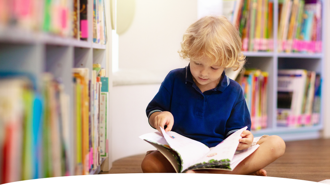 enfant 4 ans qui lit à la bibliothèque